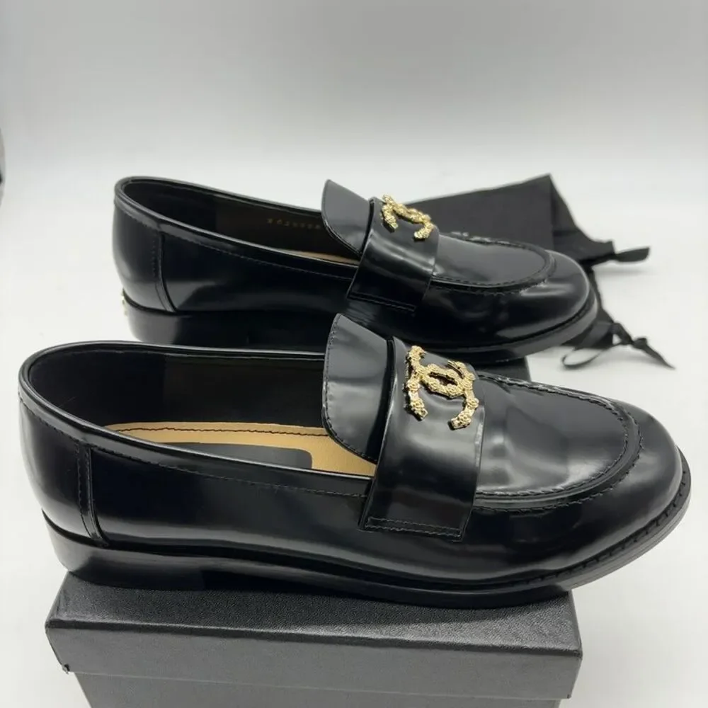 CHANEL Black Leather Women Loafers with Gold CC Emblem.